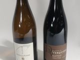 two bottles of wine sitting next to each other on a white surface