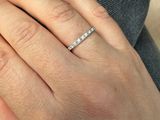 une femme qui porte une bague en diamant au doigt