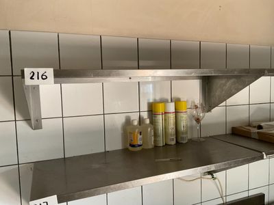 a metal shelf with bottles of condiments on it in a kitchen