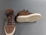 brown leather sneakers with laces on them on a gray surface