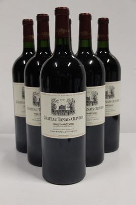 four bottles of red wine are lined up on a white surface