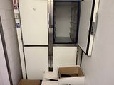a refrigerator in the middle of a room with boxes on the floor