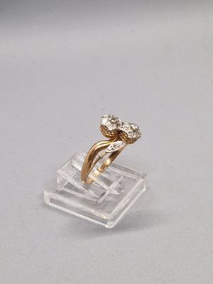 gros plan d'une bague en or surmontée d'un diamant