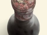 a close up of a black vase on a white surface