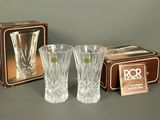 two clear glass vases and a box on a gray surface