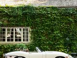 a white convertible car parked in front of a house