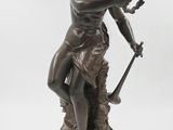 une statue en bronze représentant une femme tenant une épée, posée sur un socle