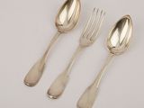 three silver spoons and a fork on a white surface