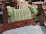 a bed that has a green and yellow striped blanket on it