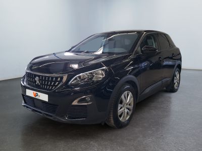 La voiture noire est garée dans une grande pièce au sol noir.