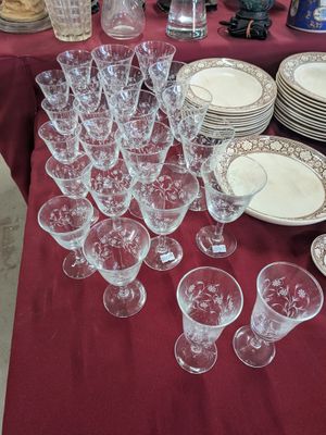 many glasses and plates on a table with a red table cloth