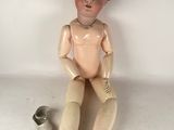 a doll sitting on the floor next to a can