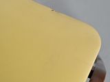 a close up of a yellow chair with a metal frame