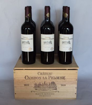 trois bouteilles de vin rouge dans une caisse en bois posée sur une table