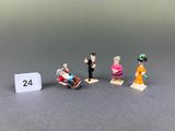 four figurines of people standing next to each other