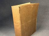 an open brown book sitting on top of a gray surface
