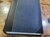 a blue book on a wooden table with a keyboard in the background