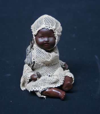 a small doll that is sitting on a black surface