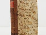 an old book with writing on it sitting on a table