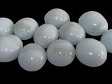 a pile of white eggs on a black background