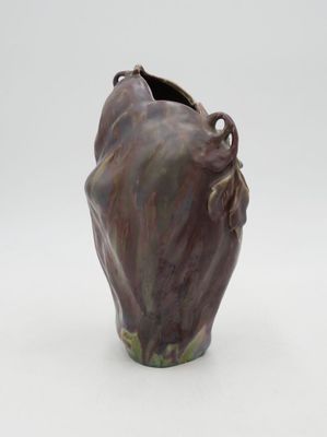 a brown vase with a face on it on a white surface