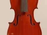 an old violin sitting on top of a white surface