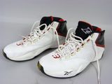 une paire de baskets blanches et rouges avec des semelles noires sur un fond blanc
