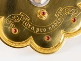 a gold clock with red jewels on it