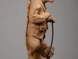 wooden sculpture of a man with a cane and a hat