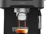 a black coffee maker with a cup of coffee in front of it