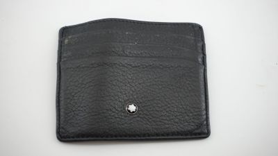 un portefeuille en cuir noir orné d'un bouton argenté sur le devant