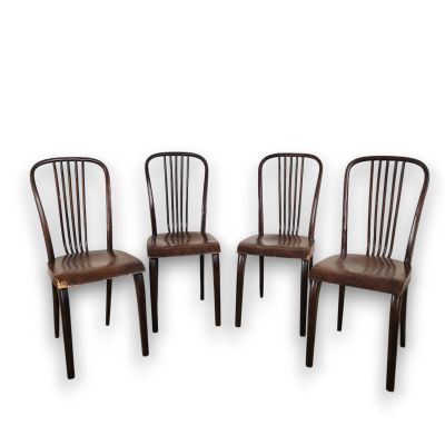 trois chaises en bois assises l'une à côté de l'autre sur une surface blanche