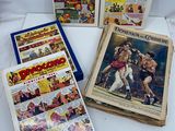 cinq bandes dessinées anciennes exposées sur une surface blanche