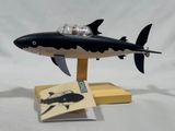 a black and white toy shark on a wooden stand