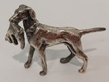 a silver dog figurine on a white surface