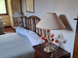 une chambre avec un lit et une table sur laquelle est posée une lampe