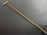 a close up of a gold chain bracelet on a black surface