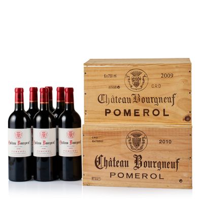 quatre bouteilles de vin dans un coffret en bois posé sur une surface blanche
