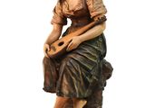 statue of a woman sitting on a rock with a guitar