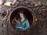 a silver vase with a picture of a woman on it