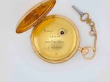 a gold pocket watch with a key on a chain