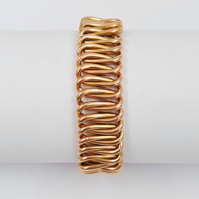 un gros plan d'un bracelet plaqué or posé sur une serviette
