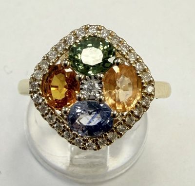 une photo d'une bague en diamant multicolore posée sur un socle transparent
