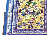 a close up of a blue and yellow table cloth with a bird on it