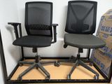 two black office chairs sitting next to each other in a room