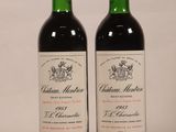 two bottles of red wine sitting next to each other on a table