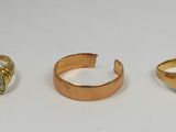 three gold rings and a ring with a black stone