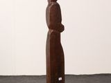 wooden sculpture of a woman standing on a pedestal in a room