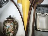 a vase and a paddle on a shelf next to a wall