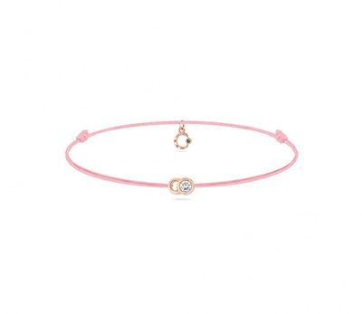 un bracelet en cordon rose orné d'un pendentif en forme de cœur et d'un diamant